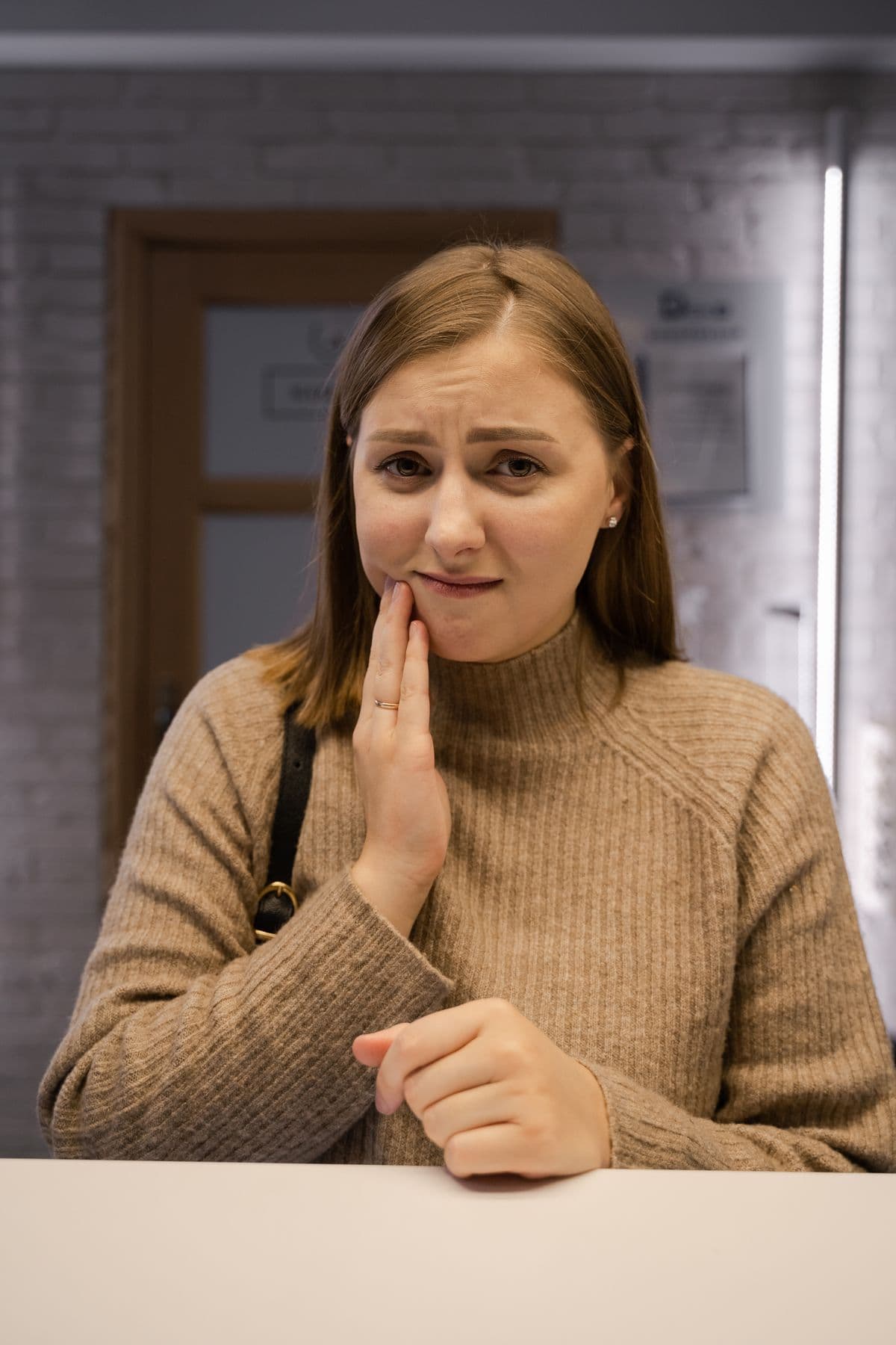Woman holding her jaw in pain from a dental emergency