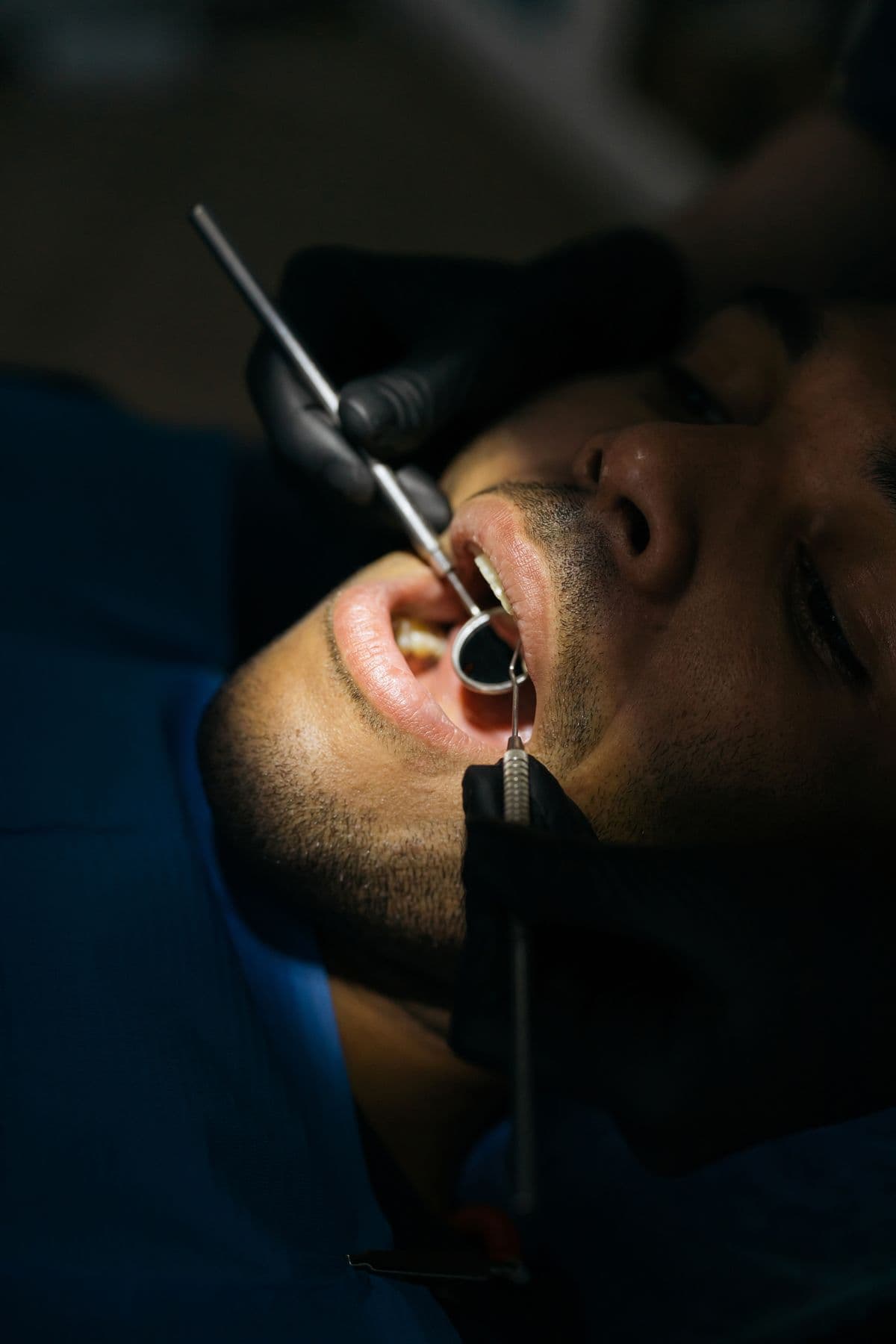 Dentist examining a patient's teeth with a dental mirror