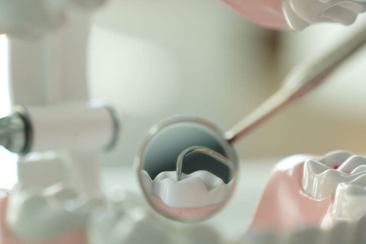 Close-up of a dental mirror and probe examining a set of teeth