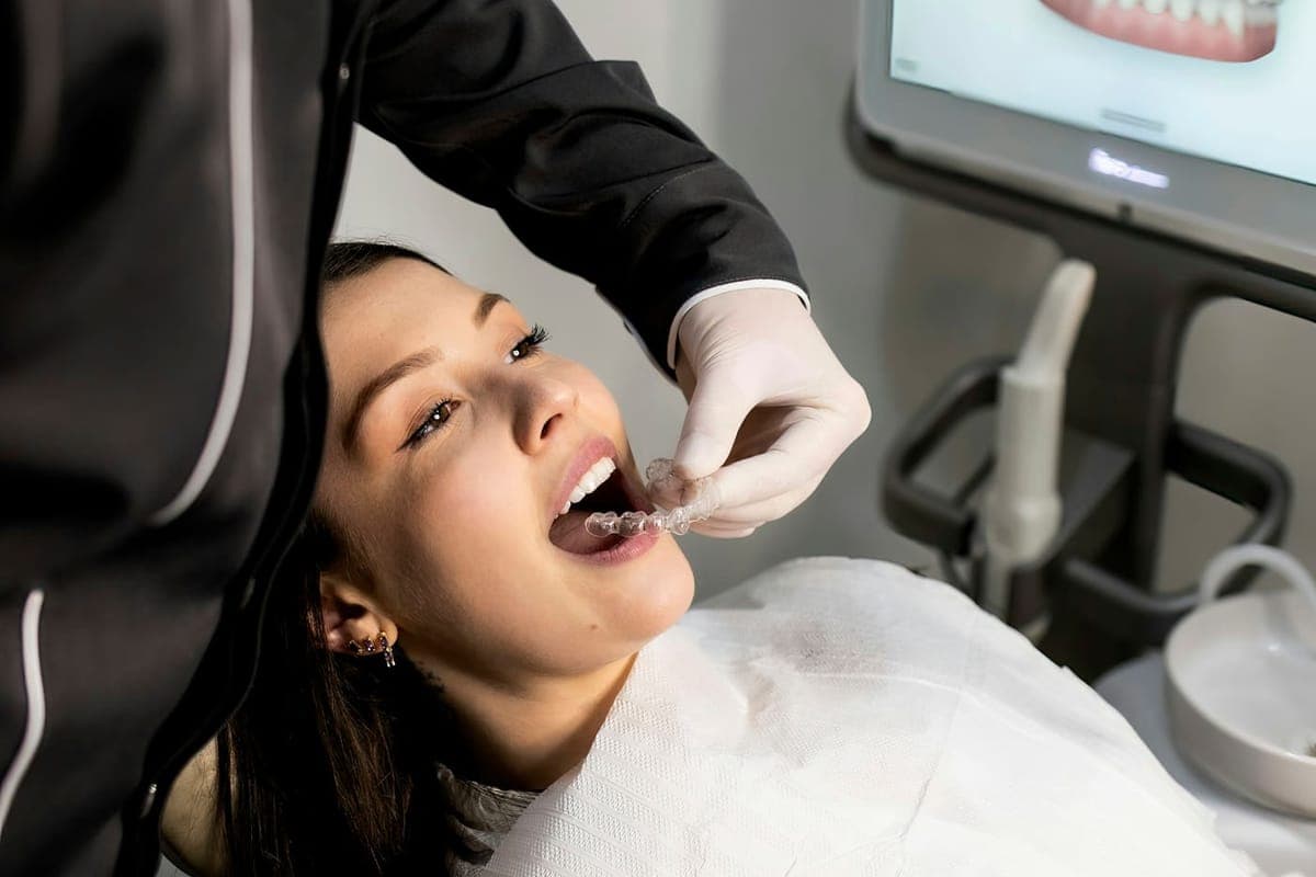 A dentist reviewing a patient's dental imaging on a chairside screen